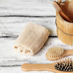 Bath set on a white wooden background. Washcloth, razor, brush and comb