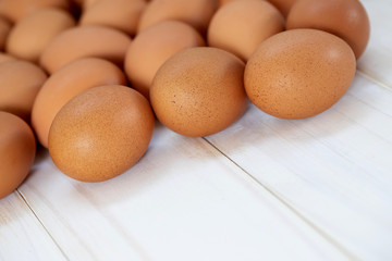 fresh chicken eggs from above on a white wooden background. Text space pattern.