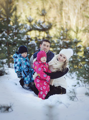 Happy family at winter snowy forest