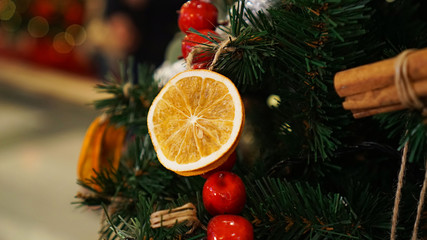 Fototapeta na wymiar Christmas decorations on the Christmas tree. Cinnamon and lemon. 