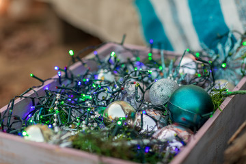 Christmas composition. Wooden box with Christmas toys, tinsel and garlands. New Year.