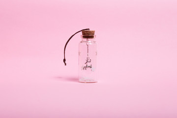 Christmas decoration Christmas deer in a small glass bottle stands on a pink background