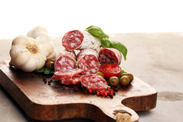 thinly sliced salami on a wooden texture on the background.