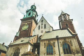 Fototapeta na wymiar Wawel Cathedral on Wawel Hill, Sigismund's Chapel with a gold dome and Vasa Dynasty chapel in Krakow, Poland. Shot from below