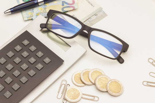 Calculadora, gafas y documentos; monedas de dinero y calculadora; calculando los beneficios de la empresa; preparando la declaraci&oacute;n de impuestos