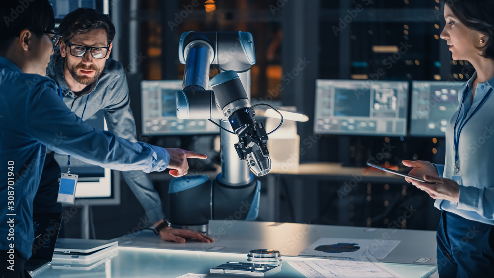 Leinwandbilder diverse team of engineers with laptop and a tablet analyse and discuss how a futuristic robotic arm 