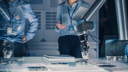 Futuristic Artificial Intelligence Robotic Arm Operates and Moves a Metal Object, Picks It Up or...