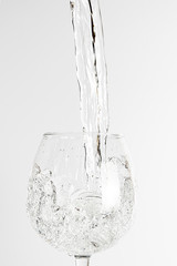 Water poured into glass, isolated on white background