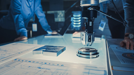 Close Up of a Futuristic Robotic Arm Picking Up a Metal Object and Moving It. Team of Engineers...