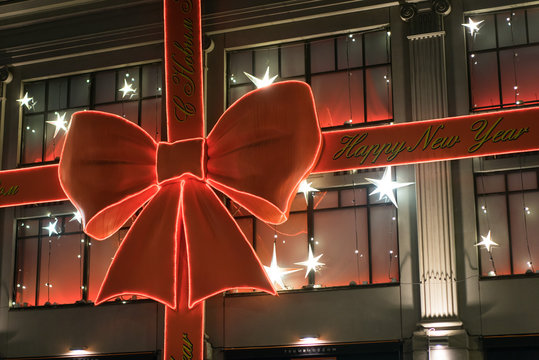 Moscow, Russia - December 9, 2019: close up facede of Universal store Central Department Store TSUM at night with Christmas design red bow.