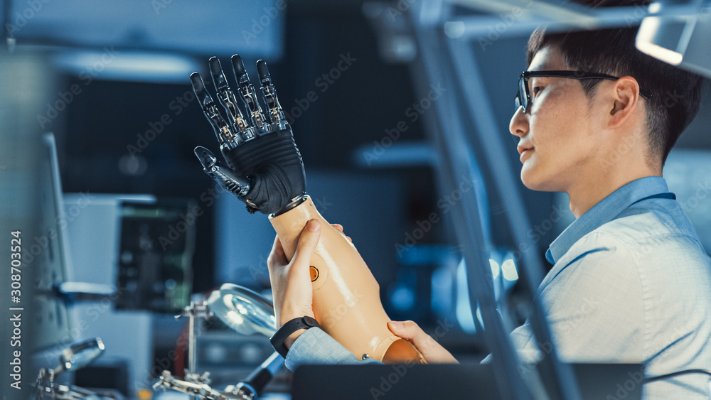 Leinwandbilder Futuristic Prosthetic Robot Arm Being Tested by a Professional Japanese Development Engineer in a High Tech Research Laboratory with Modern Computer Equipment.