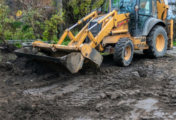Fragment of the excavator. Repair work on the street of a residential quarter.