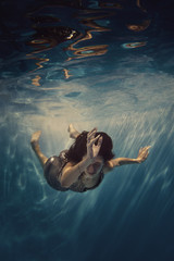 A girl in a brilliant suit swims underwater