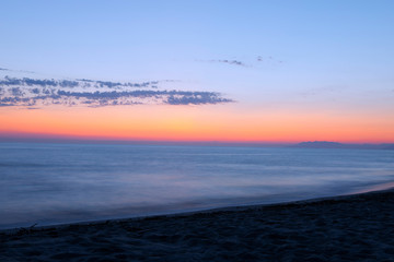 Fototapeta premium Long exposure sea landscape with dusky pink sky. Seascape with sunset sky and motion blur water. Marina di Torre del Lago Puccini, Italy.
