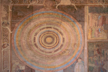 Pisa, Tuscany / Italy - 08/20/2019: Medieval astrological zodiac wheel mural inside Camposanto cemetery of Campo dei Miracoli, Christian mandala fresco on wall of Monumental Cemetery, Piero di Puccio.