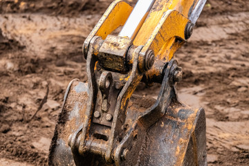 Bucket of excavator at work, construction machinery. Detail.
