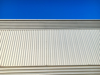 Siding metal sheet of building with blue sky.