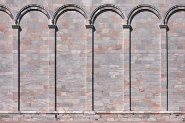 Medieval marble stone wall with arcs. Classical wall with columns and arches. Architectural decoration background.