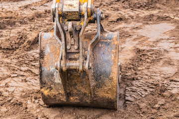 Bucket of excavator at work, construction machinery. Detail.