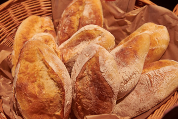 Whole grain buns in the basket. A bunch of fresh made loafs in the grocery store. Rustic bakery product.