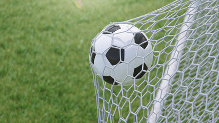 3D illustration Soccer ball flew into the goal. Soccer ball bends the net, against the background of grass. Soccer ball in goal net on grass background. A moment of delight
