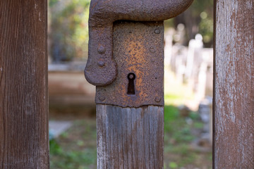 Rustic rusty keyhole. Old historic wooden gate with metal lock close up. Medieval, tarnished gate lock. Detail of old Middle Ages gate.