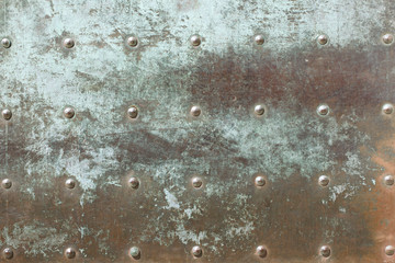 Very old, heavy iron door close up surface. Tarnished, rusty metal texture with rivets pattern. Grunge green patina medieval door. Copper Bronze patina background. 