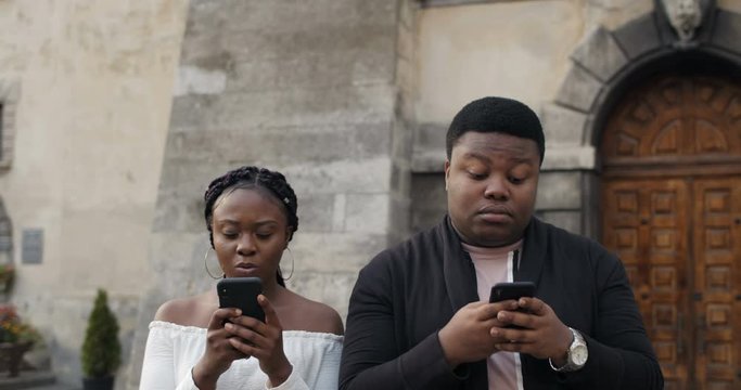 Close uop of couple using their smartphones outdoors.