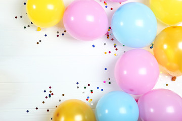 balloons and confetti on color top view. Festive background with place for text.