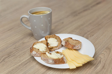 Tea with lemon, sliced bread with cheese and sandwiches