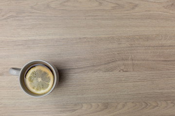 Tea with lemon in a porcelain Cup on a wooden background