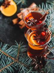 Winter hot drink Christmas mulled wine in glasses with anise, cinnamon and tangerine