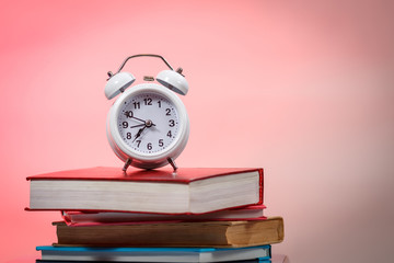 Alarm clock stack of books table. Education concept.