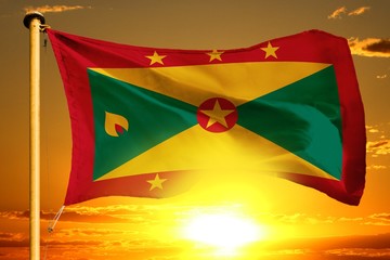 Grenada flag weaving on the beautiful orange sunset with clouds background