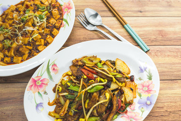 Stir-fry spicy sliced beef with bean sprouts, dried chillies and spring onions, and mapo doufu bean curd. Authentic China, Chinese Asian food on table.