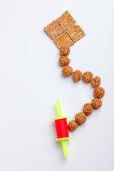 Til Gul OR Sweet Sesame Laddu in glass bowl with Fikri for Indian festival Makar Sankranti over white background 