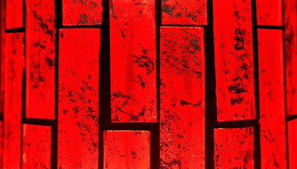 A color macro image of vertical glass bricks that are back lit with a red light.