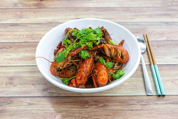 China Chongqing Sichuan spicy dried chilli small lobsters, with chopsticks & spoon. Isolated food photography at Chinese restaurant.