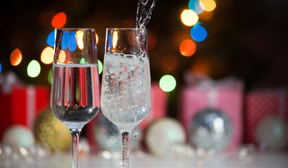 Beautiful splash of champagne glasses and Christmas lights