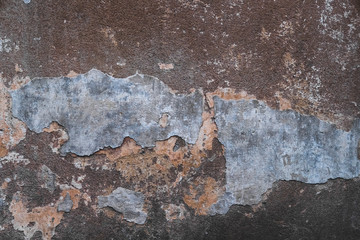 Abstract grunge texture of old colorful wall with cracks and scratches. Creative background. Blue, grey, orange and brown rough weathered stone texture with stucco and paint. Copy space