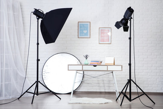 Photo studio with professional equipment and home interior on brick wall background