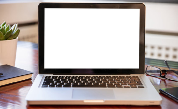 Laptop with white blank screen on a wooden desk