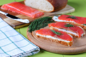 Slices of slightly salted salmon on pieces of wheat bread. 