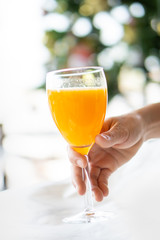 hand holding a glass of orange juice