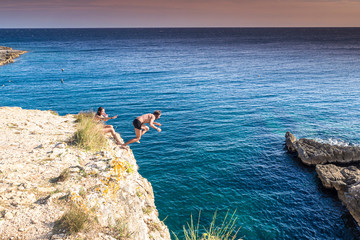 Croatia, Istria, Pula, Cape Kamenjak, man jumping from a cliff