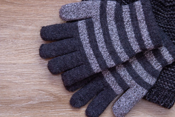 winter gloves with hat,gray gloves and hat knitted for boy on wooden background