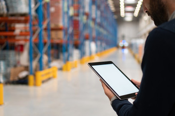 Manager holding digital tablet in warehouse	