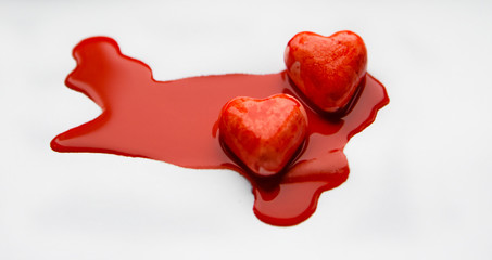 two red hearts in red paint like blood