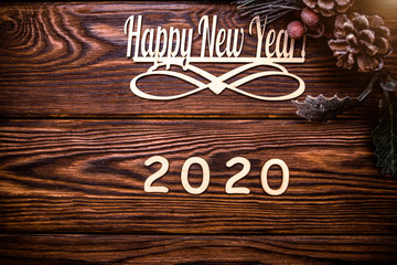 Happy new year 2020 on wooden brown background.