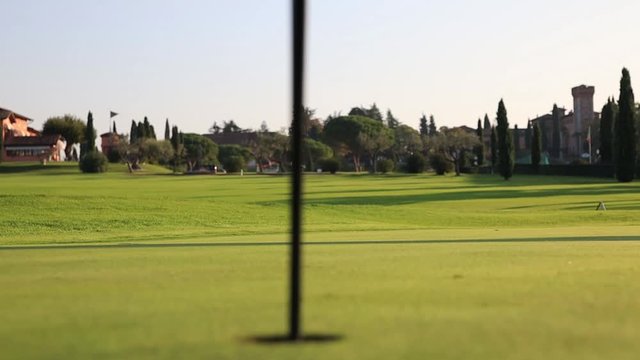 Perfect Grass on Green Golf Course With Flag And The Hole. Sport And Leisure Concept